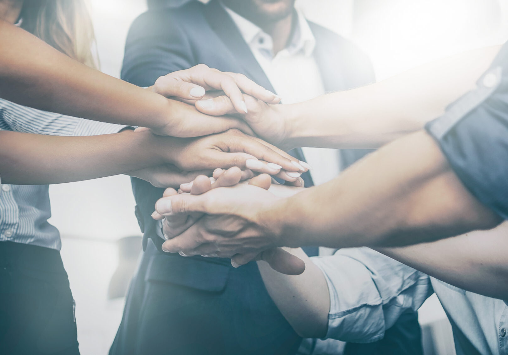 Close up view of young business people putting their hands together. Stack of hands. Unity and teamwork concept.